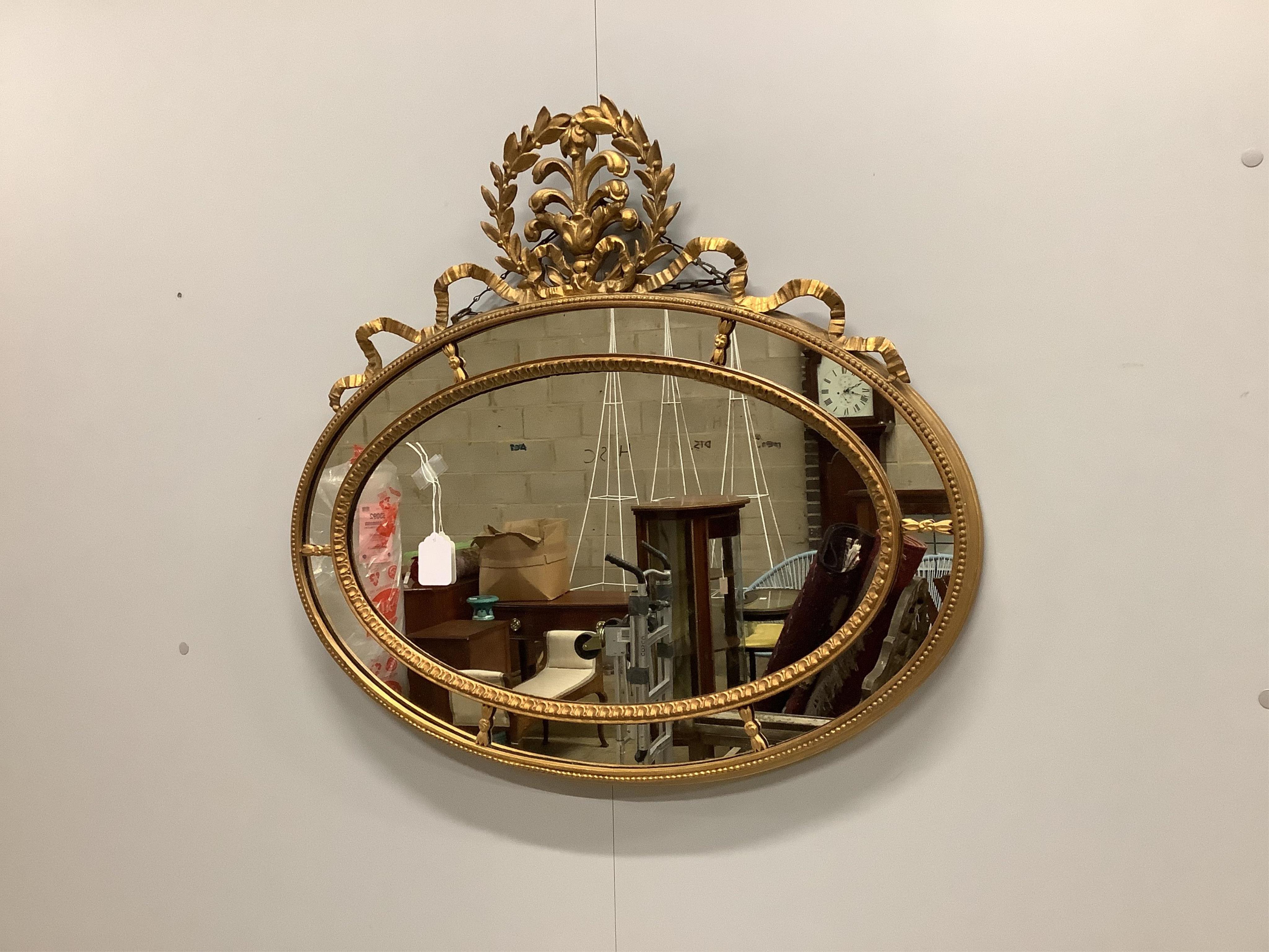 An Edwardian giltwood and composition oval marginal plate wall mirror, width 76cm, height 69cm. Condition good.